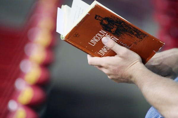 TIME OUT: ASU Alumnus Jake Serago reads a book in between sets at the Women's Volleyball game on Sept. 23. (Photo by Rosie Gochnour)