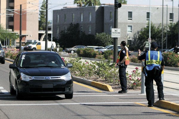 Sergeant J. Carlos Escudero directs traffic during the Fall Welcome Ceremony on Tuesday. ASU police are introducing a task force to control traffic issues near ASU’s Tempe and Polytechnic campuses. (Photo by Sam Rosenbaum)

