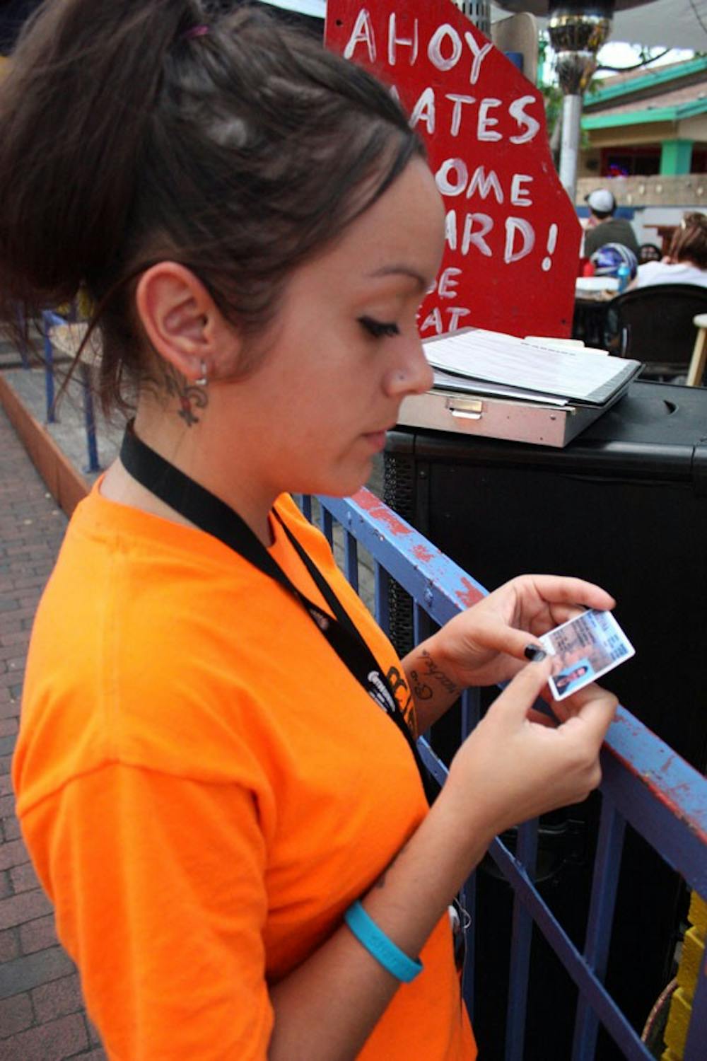 HARDER TO FAKE: Mallory Cuevas checks an I.D. at Barney's Boathouse in Tempe Monday evening. (Photo by Kyle Thompson)