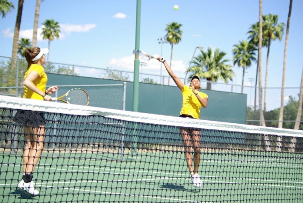 Postseason Push: ASU junior Sianna Simmons reaches for the ball over her head during doubles play while senior Ashlee Brown looks on against UC Irvine on March 22 in Tempe. The Sun Devils travel to Ojal, Calif., to compete in the Pac-10 Championships on Thursday. (Photo by Nathan Meacham)