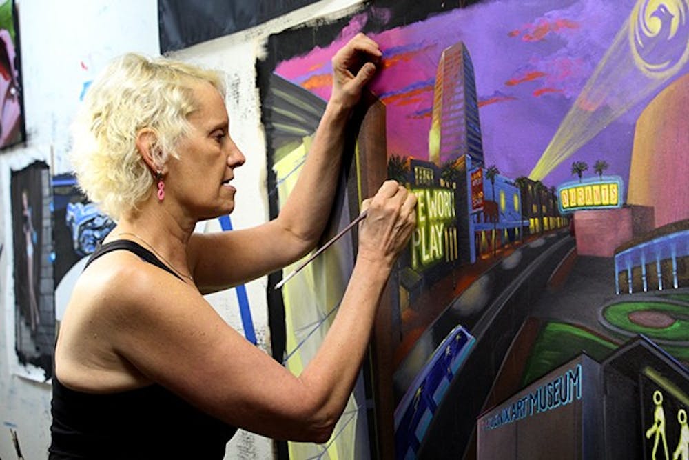 Longtime artist, Lucretia Torva works on a mural for the Phoenix Wayfinding Art Project. The piece is being created to help bring a sense of community to downtown Phoenix. (Photo by Tynin Fries)