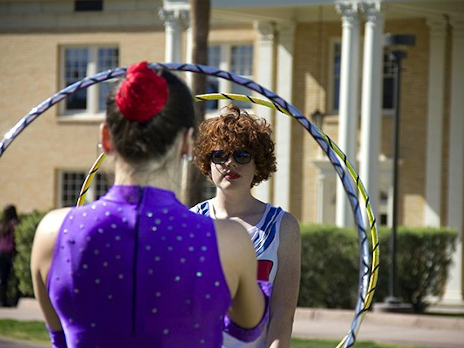 Circus performer Mary Adrenaline teaches ASU sophomore earth and space exploration major Bridget Russell how to hoop on Hayden Lawn. The Arizona Circus School performed on the Tempe campus today with Project Humanities. (Photo by Diana Lustig)