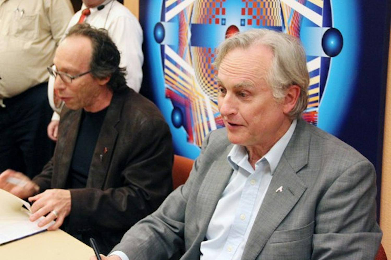 Richard Dawkins, right, and Lawrence Krauss, left, sign books at the "Something From Nothing?" event. (Photo by Diana Lustig)