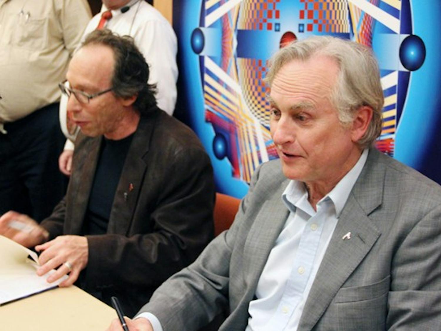 Richard Dawkins, right, and Lawrence Krauss, left, sign books at the "Something From Nothing?" event. (Photo by Diana Lustig)