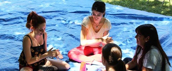 (Left to right) Maddie Rufo, Kendra Clement and Cheyenne Smith sing a cup song. They are from AZ Golden Rule Education Efforts (A.G.R.E.E.), where they teach students the golden rule. (Photo by Edward Hernandez)