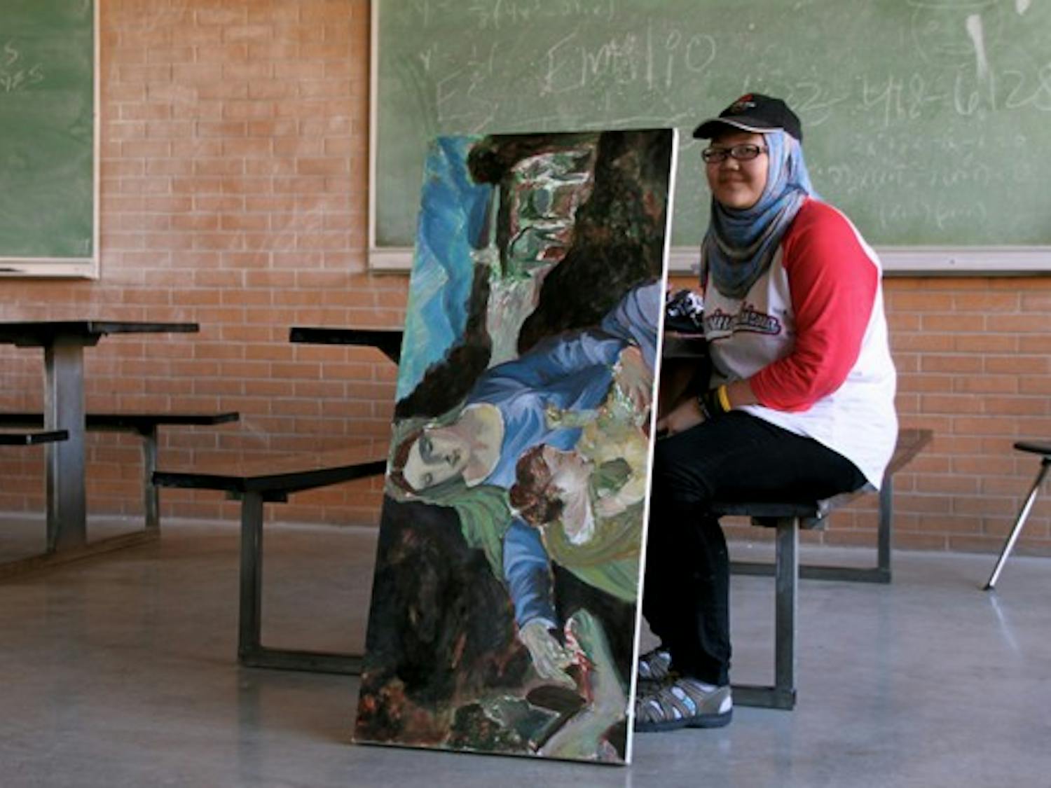 LADY IN PAINTING: Painting senior Kadhima Tung waits between classes with her latest piece of art outside of the Physical Sciences Center Oct. 26. (Photo by Rosie Gochnour)