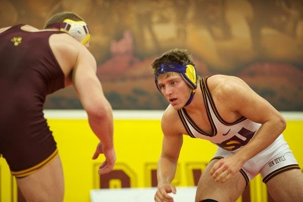 MAT STRATEGY: Freshman Wesley Moore sizes up his opponent, a teammate, during the Sun Devils Wrestle-Offs two weeks ago. Moore is one of 16 freshman on this year’s team that coach Shawn Charles hopes will benefit from a strong core of seniors. (Photo by Michael Arellano)