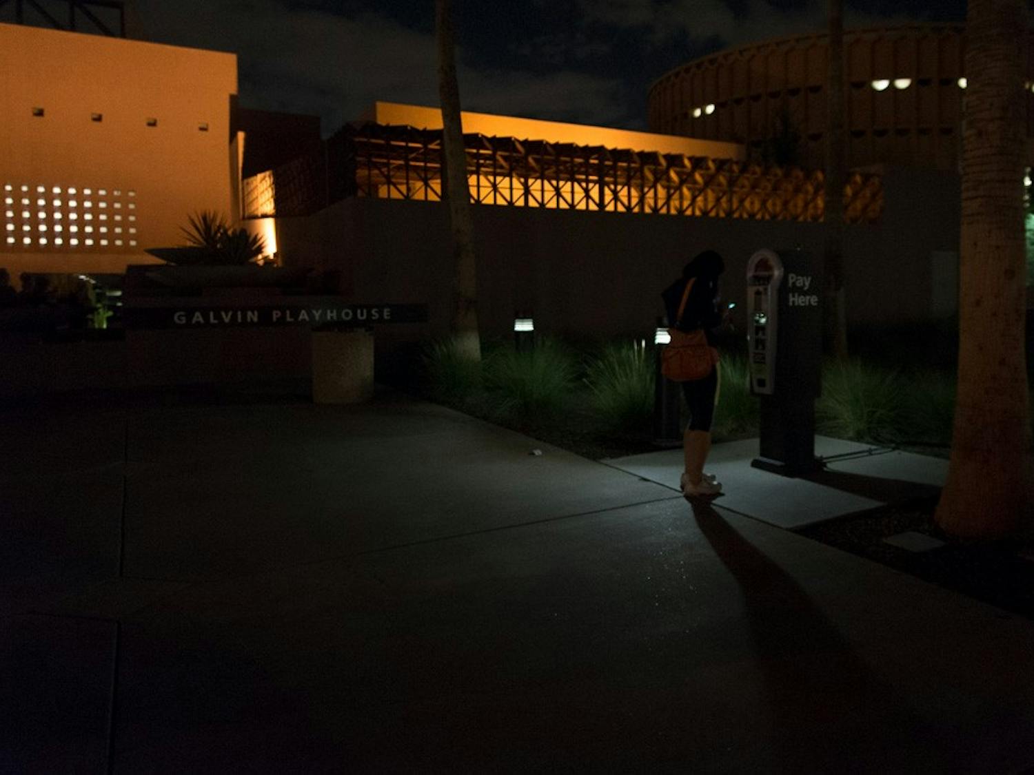 A woman pays for parking in a dimly lit area outside the Galvin Playhouse on Monday, Oct. 5, 2015, on the Tempe campus.