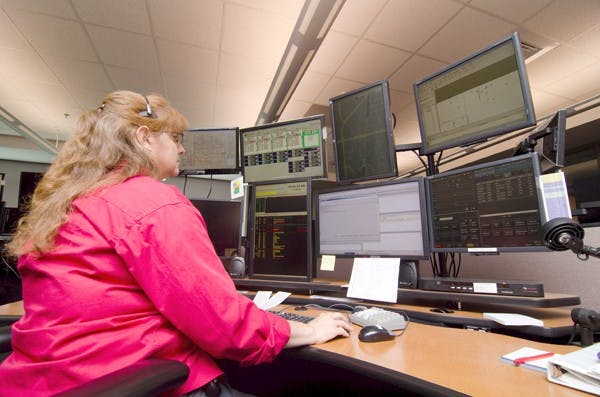 HIGH TECH RESPONSE: Tempe Police dispatcher Liz Murphy responds to emergency calls on Friday using the new Computer Assisted Dispatch, or CAD, system.  (Photo by Aaron Lavinsky)