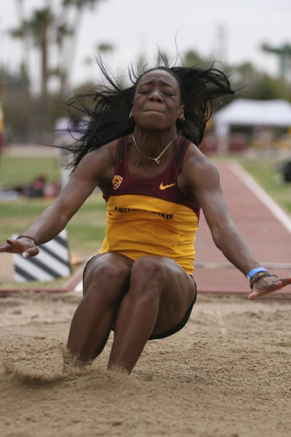 Senior multi-event specialist Christabel Nettey sprays some sand as she lands in the long jump on Feb. 17, 2012. Nettey stepped up after senior Keia Pinnick went down with a minor injury and led the women to a second place finish. (Photo by Samuel Rosenbaum)