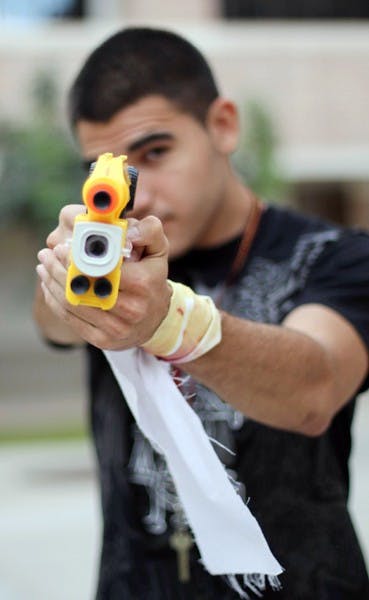 FREEZE: Freshman psychology major Macario Candia poses with his Nerf gun on the West campus Tuesday afternoon.  Candia is a "human" in the Humans v. Zombies game put on by the West campus RHA occurring all week. (Photo by Lisa Bartoli)