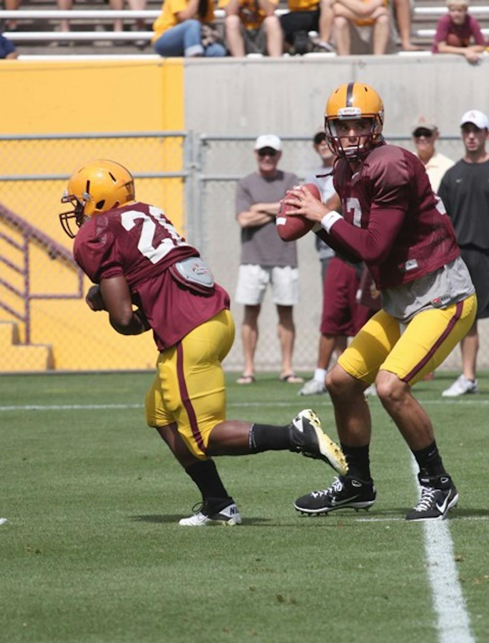 Redshirt freshman offensive lineman Evan Finkenberg and redshirt junior center Garth Gerhart wait between plays during Friday's mock game at Sun Devil Stadium. (Photo by Scott Stuk)