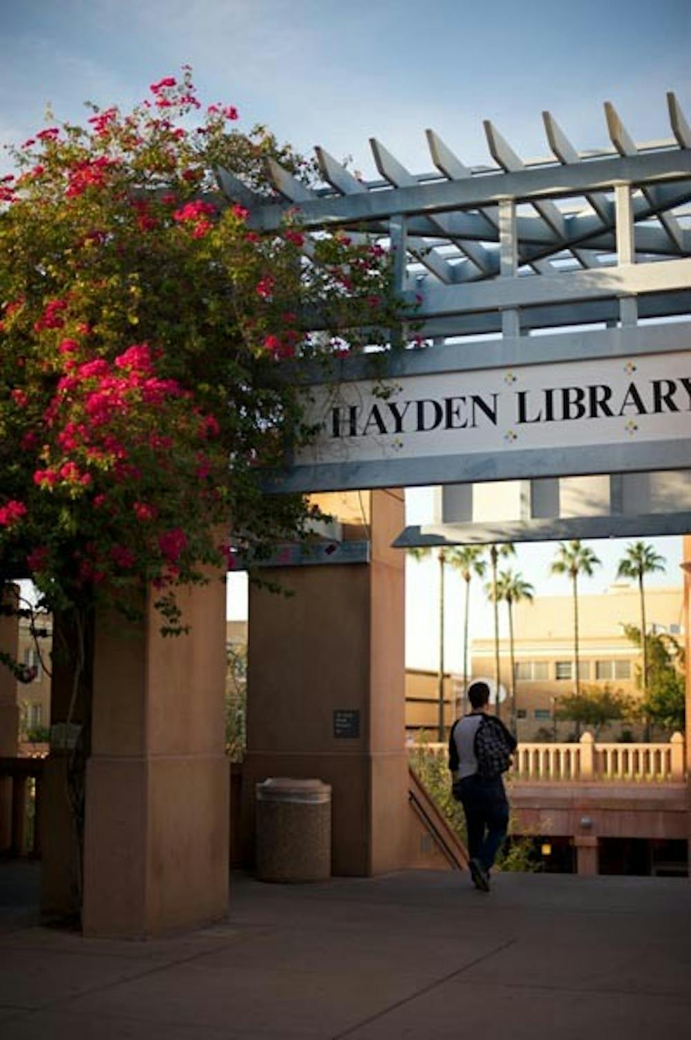 BOOK SHIPPING: Students descend the main staircase to Hayden Library on the Tempe campus. The ASU library system is now allowing students outside the Phoenix area to ship return books at no cost. (Photo by Michael Arellano)