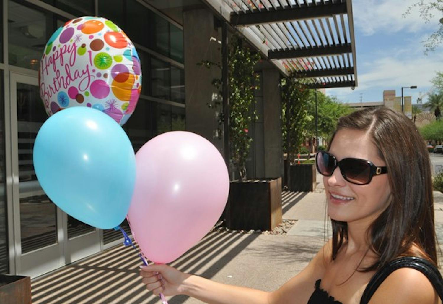 HAPPY BIRTHDAY: Emily Parks, a sophomore in social work shows off balloons for her roommate's birthday outside of Taylor Place on the downtown campus. (Photo by Christopher Leone)