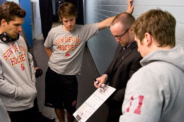 Before a game, coach Powers goes over the game and plan for the night. (Photo by Ana Ramirez)