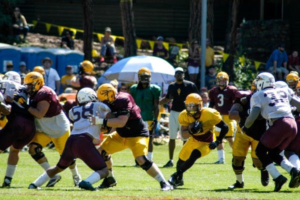 Junior running back DJ Foster runs through the line during 11 on 11 drills at Camp Tontozona. (Photo by Fabian Ardaya)
