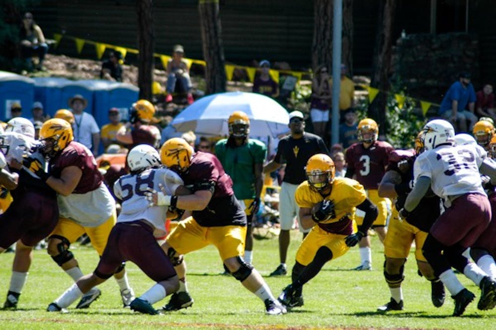 Junior running back DJ Foster runs through the line during 11 on 11 drills at Camp Tontozona. (Photo by Fabian Ardaya)