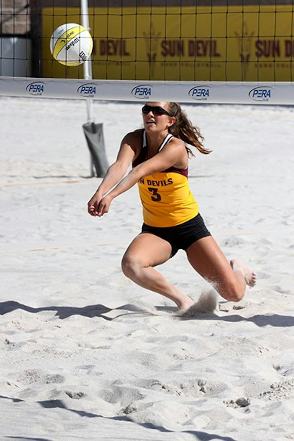 Freshman Genevieve Pirotte digs a ball in the sand volleyball program’s first home match on Wednesday, March 26 at the PERA Club in Tempe. Pirotte and her partner, freshman BreElle Bailey, lost their game in three sets. (Photo by Benjamin Margiott)