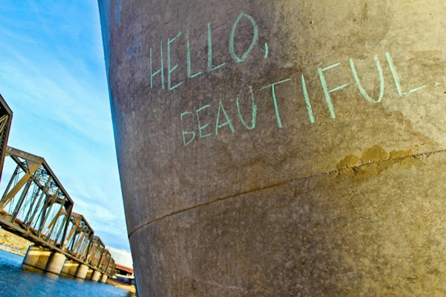 The words "Hello Beautiful" are written in chalk underneath the METRO Light Rail bridge near Tempe Town Lake. (Photo by Marissa Krings)