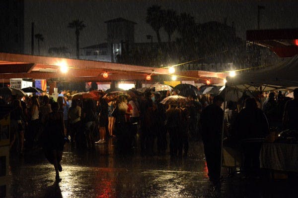 Dozens crowd under umbrellas as rain falls on the Chile Pepper Festival WHERE on Saturday, Sept. 27, 2014. (Photo by Jonathan Williams)