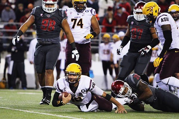 Redshirt junior quarterback Taylor Kelly is tackled by the Cougars defense at a road game in Washington. ASU defeated Washington State 55-21. (Photo by John Freitag, Daily Evergreen) 