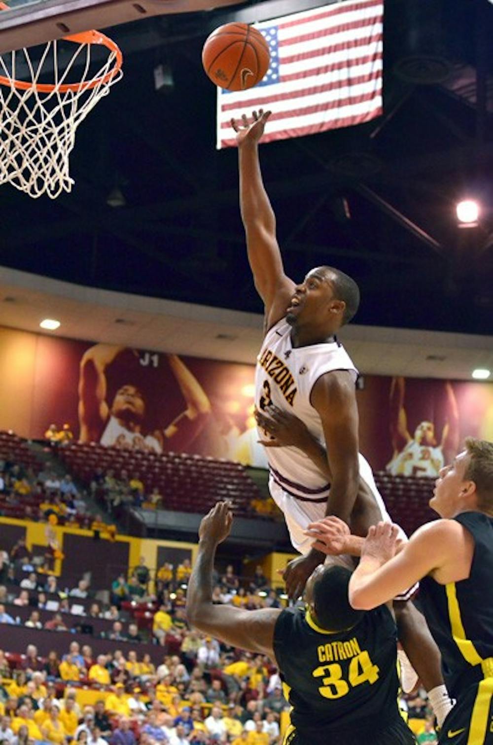 Lifted: ASU senior guard Ty Abbott sores over Oregon redshirt senior forward Joevan Catron during the Sun Devils’ 20-point victory over the Ducks in Tempe Thursday night. Abbott and fellow senior Rihards Kuksiks scored 22 points each in the game. (Photo by Aaron Lavinsky)