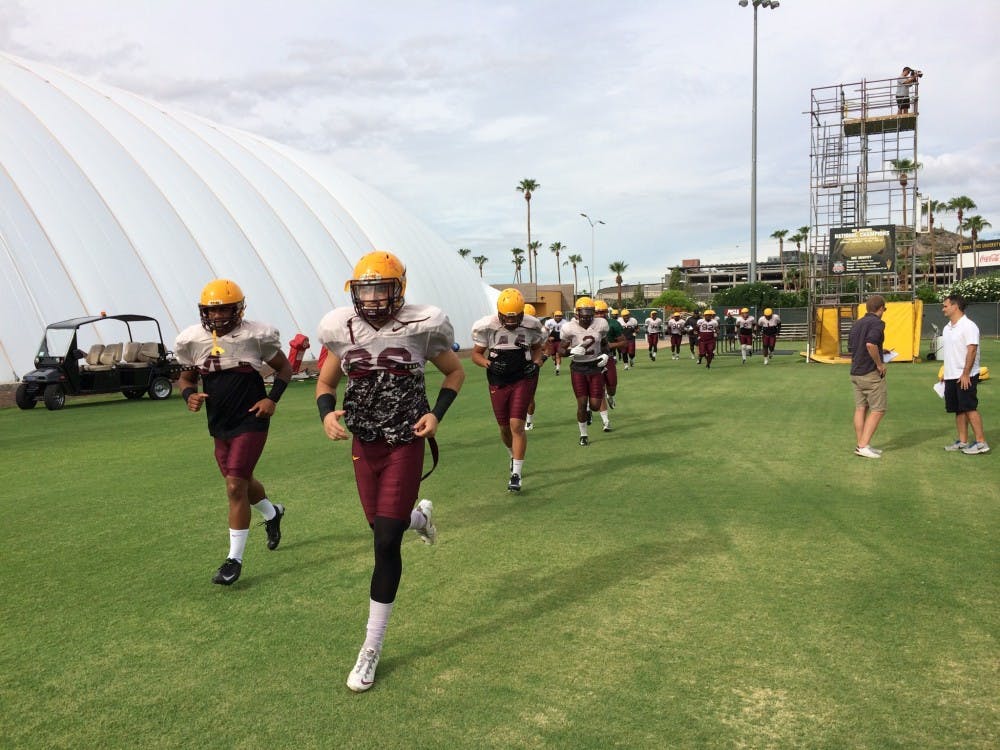 Redshirt sophomore linebacker Laiu Moeakiola, wearing a green no-contact jersey, runs out with the linebackers at Tuesday's practice. (Photo by Evan Webeck)