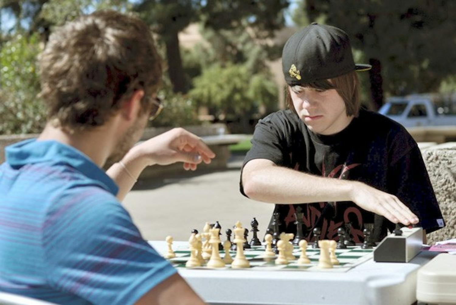 FRIENDLY MATCH: Junior Eugene Turetsky (left) and freshman Alex Scott (right), both members of the Chess Club, table outside of the MU in order to attract interest by participating in games themselves. (Photo by Sierra Smith)