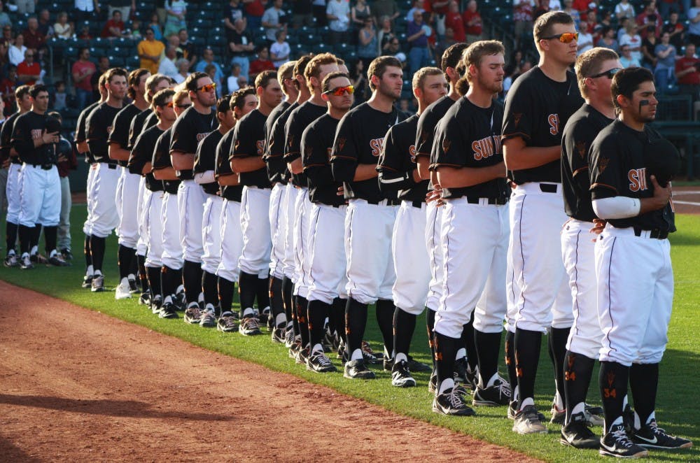 The ASU baseball team rests their caps over their hearts before a game during the Coca-Cola Classic at the Surprise Baseball Stadium on March 2. The Sun Devils beat No. 2 Arkansas for a second time Saturday. (Photo by Hector Almeida)