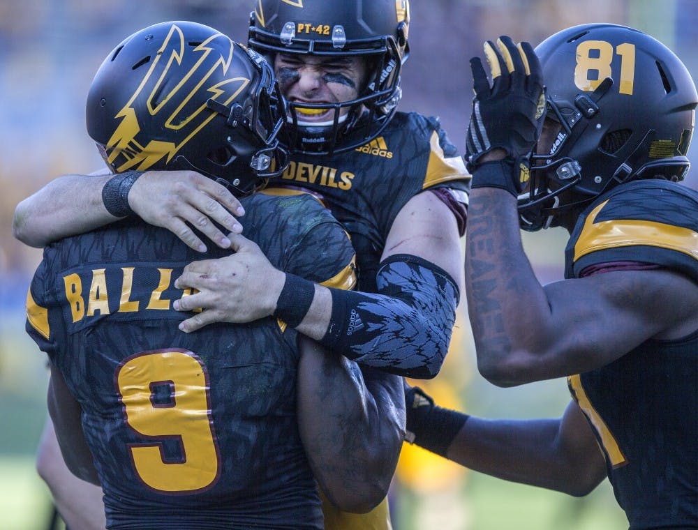 Redshirt senior wide receiver Gary Chambers, right, and redshirt senior quarter back Mike Bercovici, center, celebrate with sophomore running back Kalen Ballage, left, after his touchdown run during the fourth quarter of a game on Saturday, Nov. 14, 2015, at Sun Devil Stadium in Tempe, Ariz. ASU came back in the second half to win the game 27-17.
