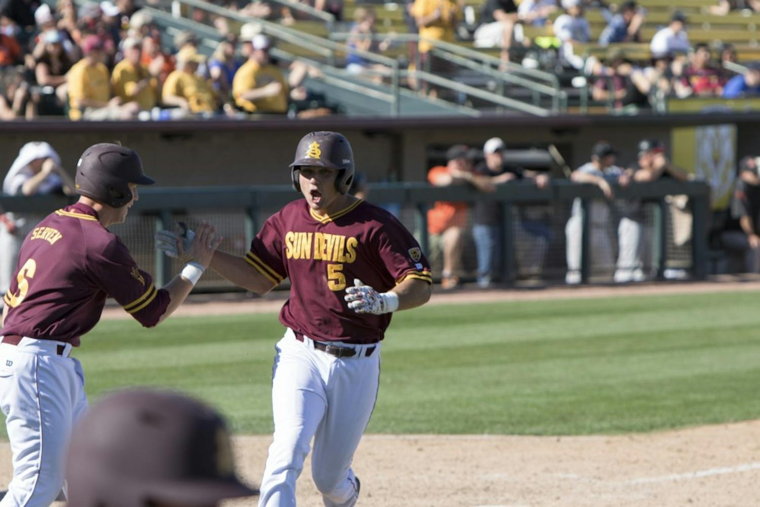 Senior Joey Bielek (right) celebrates with Sophomore Brian Serven (left) after a two-run single by Freshman Andrew Snow at Phoenix Municipal Stadium on Sunday March 15, 2015. The Sun Devils defeated the Beavers 7-3. (Jacob Stanek/ The State Press)