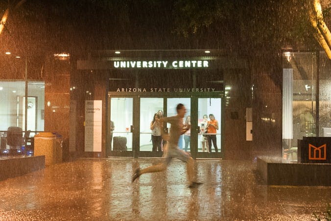 A student runs through a rainstorm on Taylor Mall on the downtown campus on Monday, Sept. 14, 2015, in Phoenix.