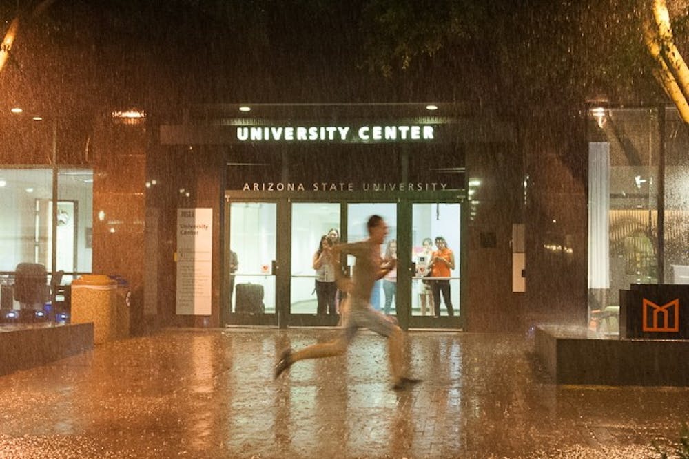 A student runs through a rainstorm on Taylor Mall on the downtown campus on Monday, Sept. 14, 2015, in Phoenix.