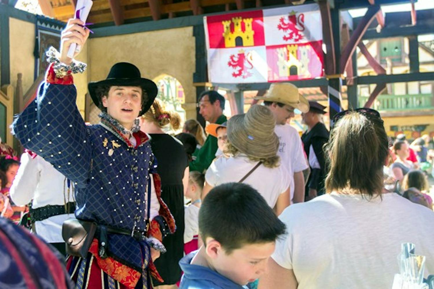 Noah Brown, who plays prince Nicholas at the Renaissance Festival, passes out diplomas of knighthood to young children at a faux knighting ceremony. Brown, an ASU student, is playing a lead role in the festival's plot this year. Click on the picture for a slideshow of the festival. (Photo by Dominic Valente)