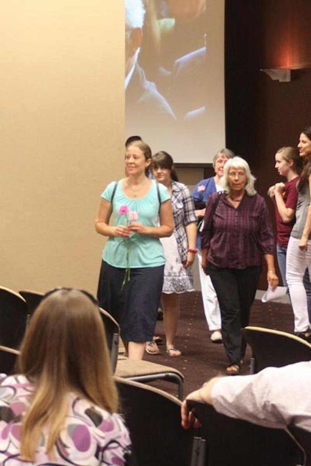 TEARING IT DOWN: Participants from the West German side break through the Berlin Wall to bring flowers to the East Germans on the other side. This interactive presentation commemorated the 20th anniversary of the fall of the Berlin Wall. (Photo by Jessica Weisel)