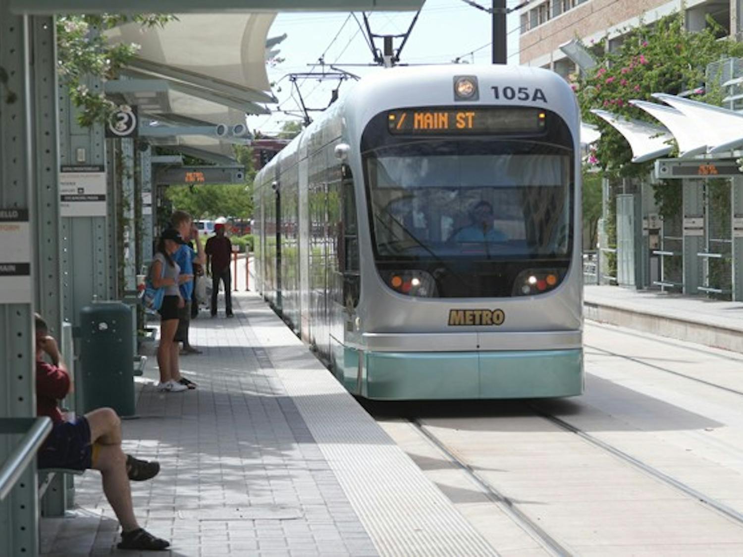 MAKING THE ROUNDS: The Metro Light Rail picks up passengers at the stop on Mill Avenue and Third Street in Tempe on August 21. (Photo by Ben Jackson)