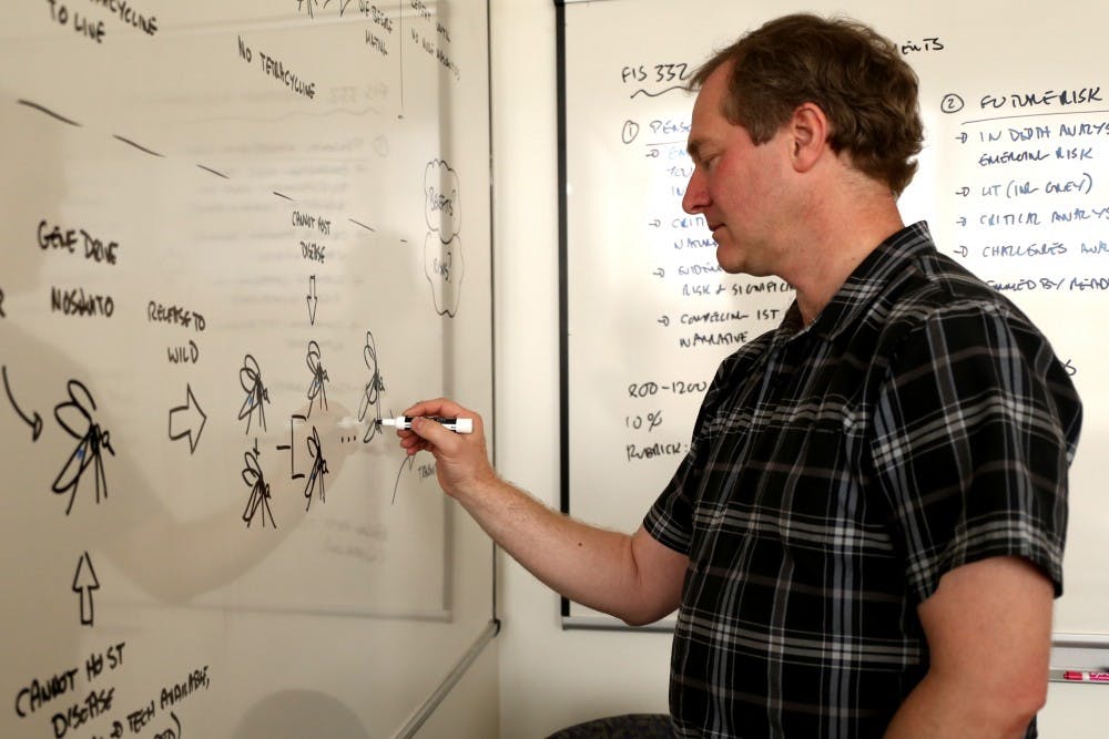 Professor Andrew Maynard of the School for the Future of Innovation in Society poses for a portrait in front of the whiteboard where he has some of Zika work displayed in his office in the Interdisciplinary B building on the Tempe campus on Thursday, Feb. 18, 2016.