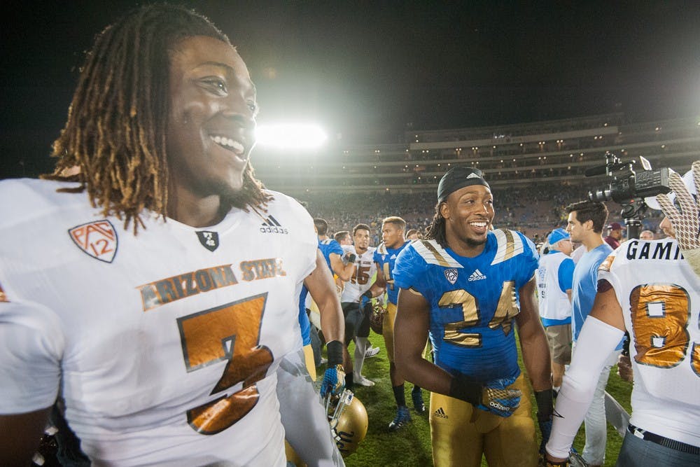 Freshman quarter back Bryce Perkins (3) and his brother, UCLA redshirt junior running back Paul Perkins, hang out on the field on Saturday, Oct. 3, 2015, at Rose Bowl Stadium in Pasadena, Calif. The Sun Devils defeated the Bruins 38-23.