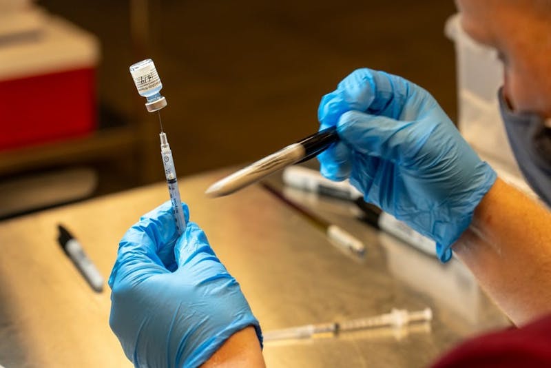 El farmacéutico Trevor Lawrence llena una jeringa con una dosis de la vacuna Pfizer en Desert Financial Arena en Tempe el miércoles 19 de mayo de 2021.