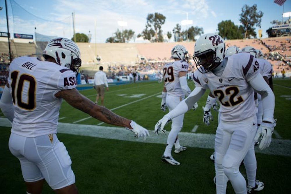 Freshman safety Marcus Ball and freshman safety Jayme Otomewo finsh off a handshake before a game against UCLA Satruday, Nov. 23. The Sun Devils defeated the Bruins 38-35. (Photo by Dominic Valente)