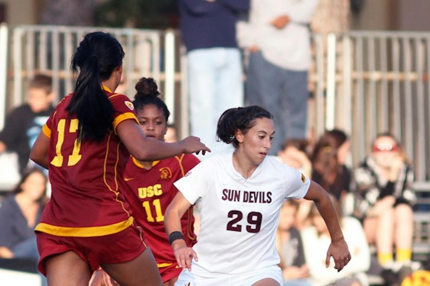 TIED UP: Senior midfielder Alexandra Elston tries to dribble past Cal junior defender Danielle Brunache during Sunday's game. The game ended in a 1-1 draw, and ASU finished the weekend without a win, having also lost to No, 1 Stanford on Friday. (Photo by Aaron Lavinsky)