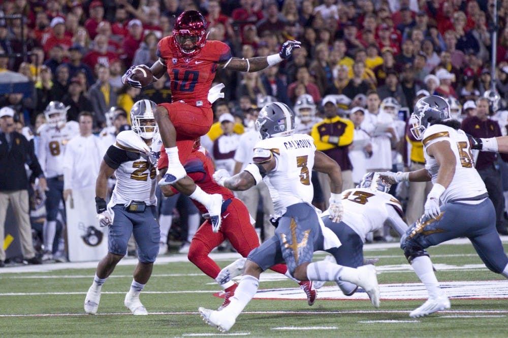 UA running back Samaje Grant hurdles an ASU defender during the first half of the annual Territorial Cup football game versus UA in Tuscon's Arizona Stadium on Friday, Nov. 25, 2016.