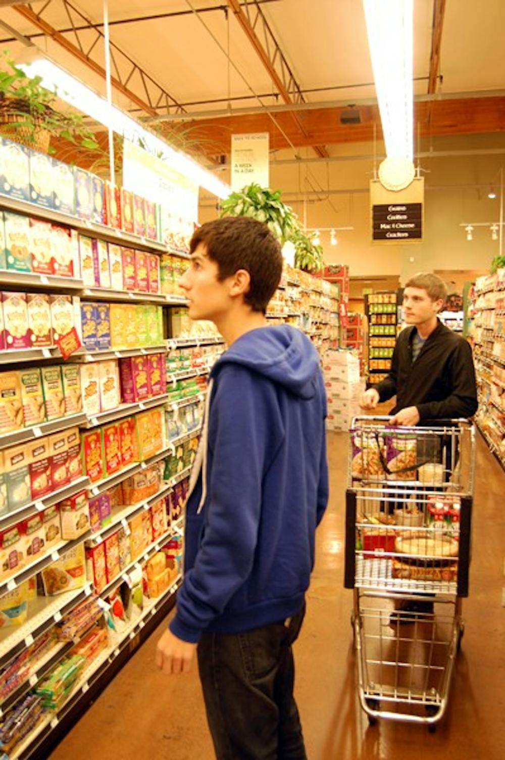 Elementary education senior, Anthony Espinoza and ASU alumnus, Charlie Jannetto carefully shop for vegan food for Thanksgiving at Whole Foods Market Tuesday night. (Photo by Thania Betancourt)