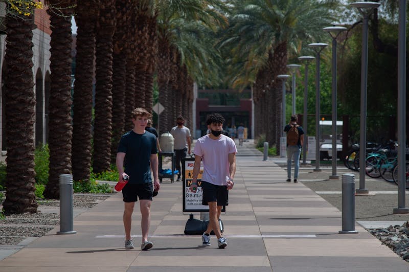 Students walk down Palm Walk on the Tempe campus on Thursday, April 20, 2021. After a year of pandemic schooling, ASU plans for a full in-person return this fall.