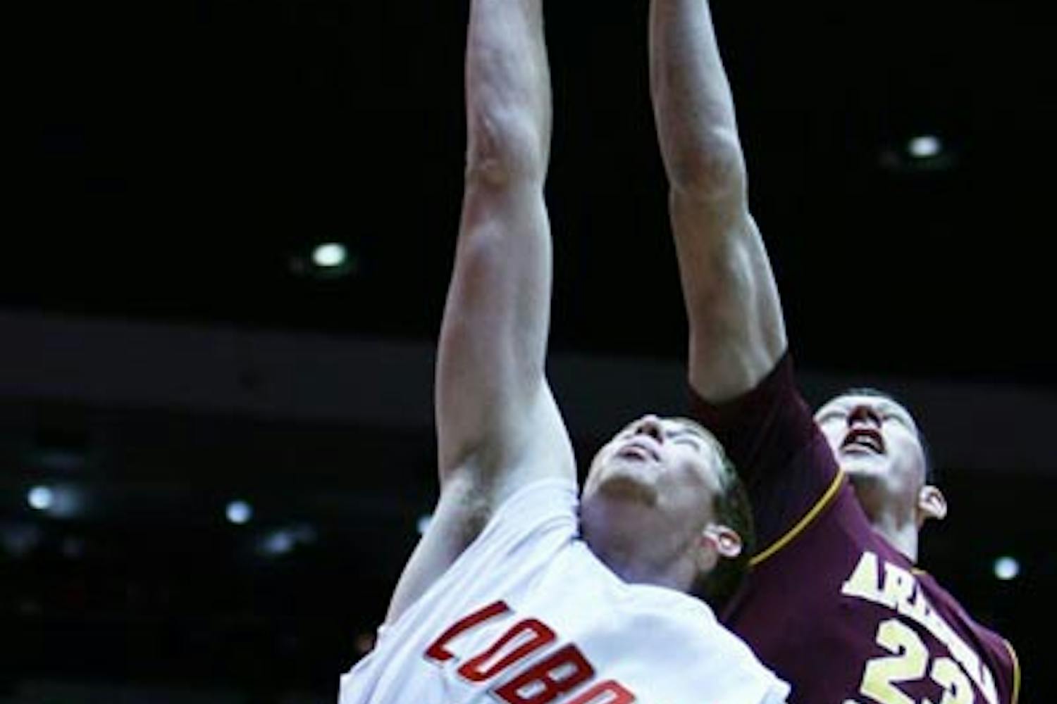 FALLING SHORT: ASU sophomore center Ruslan Pateev and New Mexico freshman center Alex Kirk battle for a rebound during Tuesday night's game in Albuquerque. The Lobos topped the Sun Devils 76-62 behind a crucial 20-0 run in the first half. (Photo Courtesy of Vanessa Sanchez)