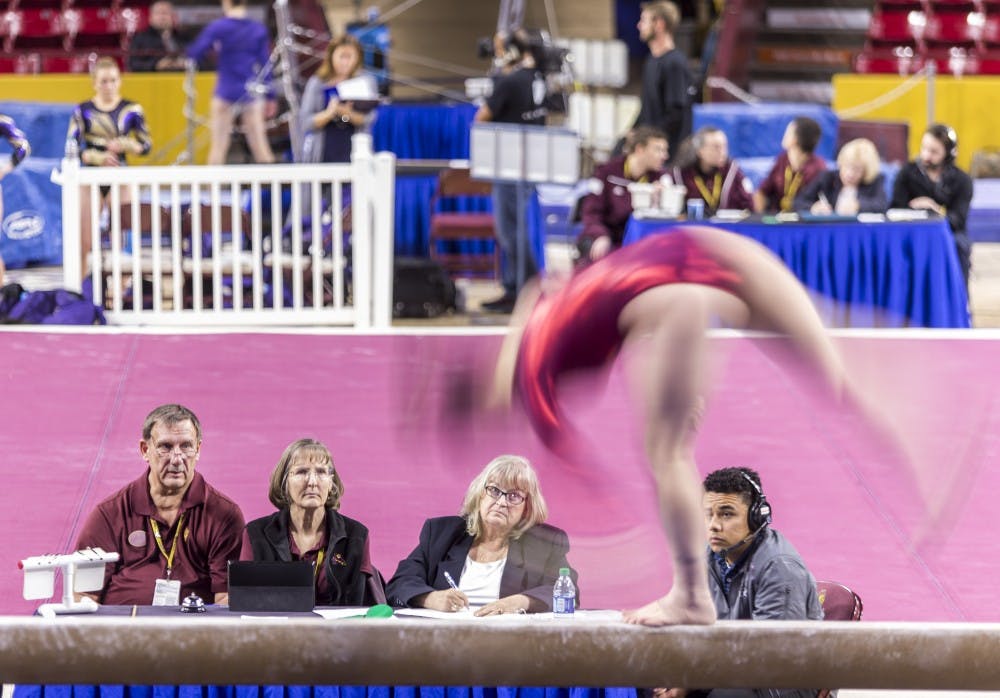 Judges watch ASU freshman Justine Callis perform on the beam during a gymnastics meet against the University of Washington Huskies at Wells Fargo Arena in Tempe, Ariz., on Monday, Jan. 18, 2015. The Huskies posted a 194.650-192.450 victory over the Sun Devils.