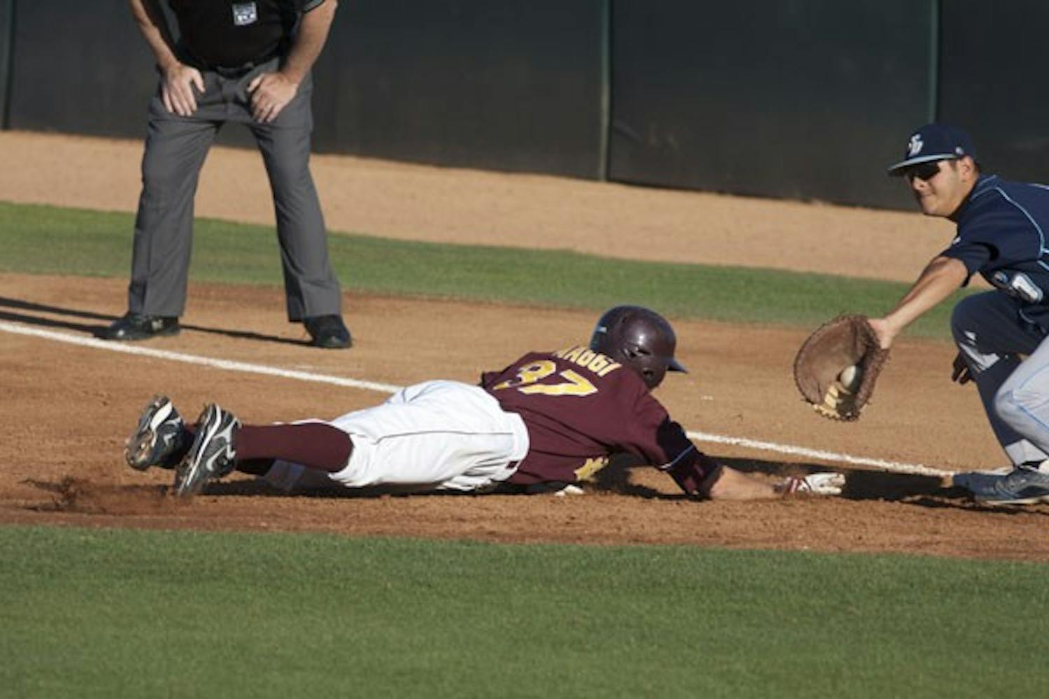 DIVING BACK: ASU sophomore shortstop Drew Maggi gets back to first base on a pickoff attempt during the Sun Devils’11-6 win over San Diego earlier this month. Maggi and the Sun Devils are currently tied for first in the Pac-10 and ranked No. 3 in the nation by Baseball America. (Photo by Scott Stuk)