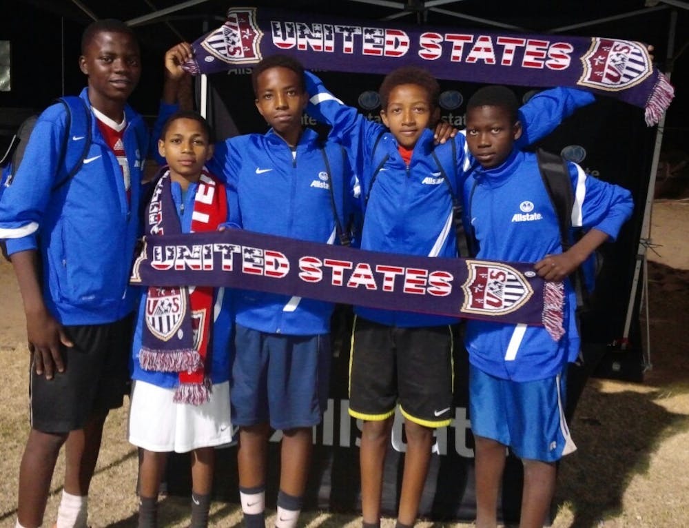 Desire Djekoula, 14,  Faysal Abillo, 14, Espoir Mutabyizigwa, 14, Yousif Andegay, 14, and  Souvenir Alagnama, 14, hold U.S. scarfs and banners. They all play for Team Milan. (Photo courtesy of Alondra Vázquez)