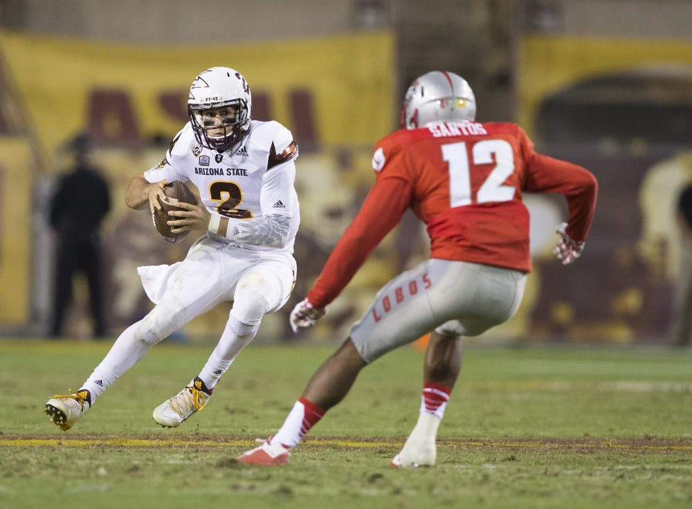 Sun Devil quarterback Mike Bercovici, left, jukes his way around safety Ryan Santos in the second half of a game against the New Mexico Lobos at Sun Devil Stadium in Tempe on Friday, Sept. 18, 2015. 