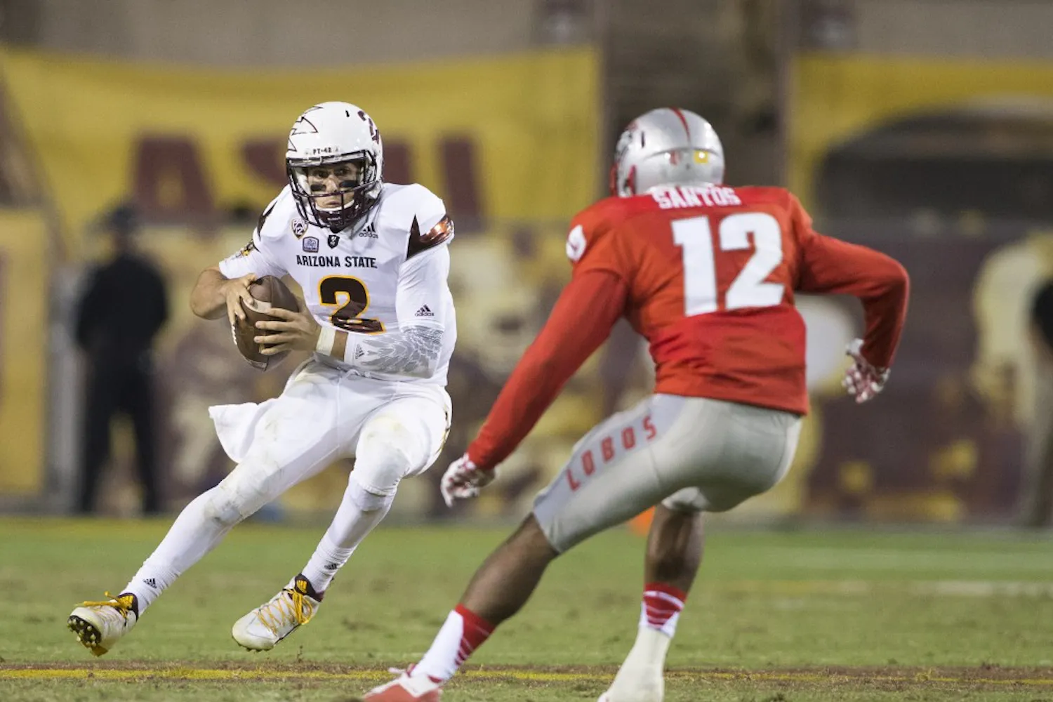 Sun Devil quarterback Mike Bercovici, left, jukes his way around safety Ryan Santos in the second half of a game against the New Mexico Lobos at Sun Devil Stadium in Tempe on Friday, Sept. 18, 2015.